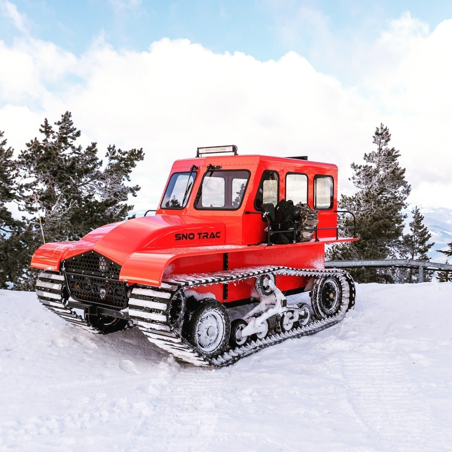 orange tracked snow vehicle mountain
