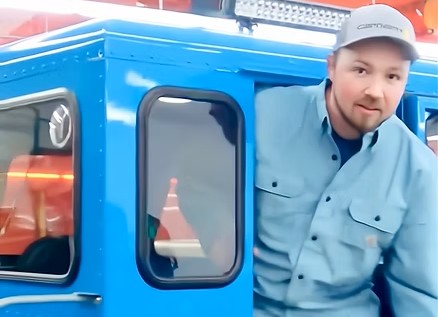 Mason standing inside a blue Sno Trac in shop
