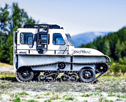 Sno Trac snow machine on a rocky mountain with trees in the background