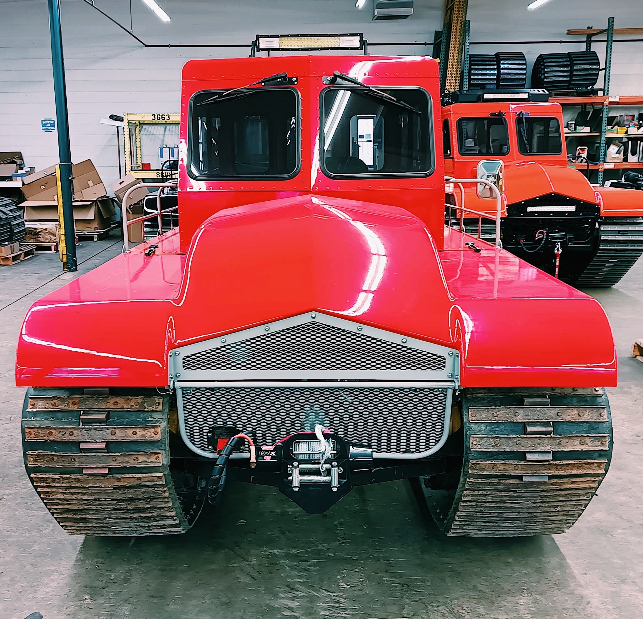 Red tracked vehicle in a warehouse setting