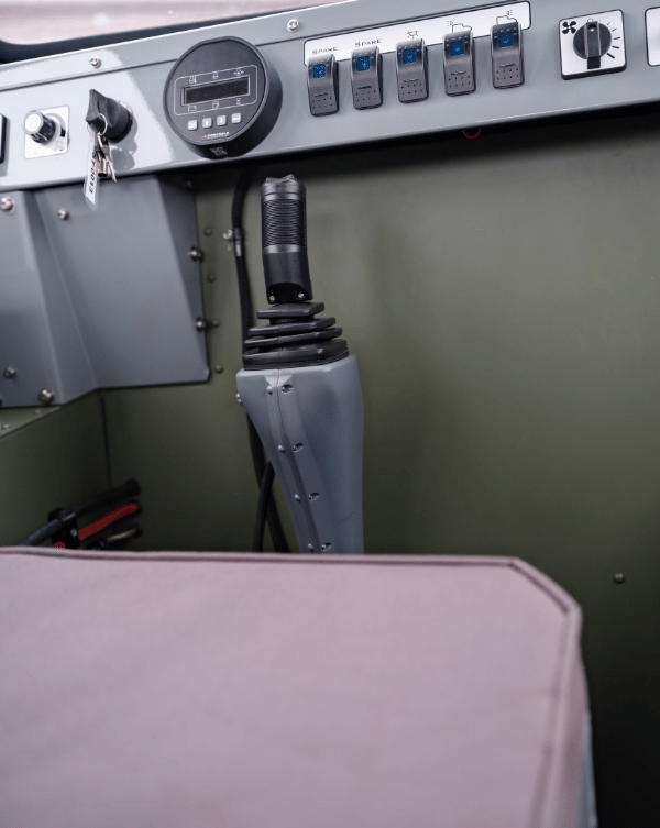 Control panel with buttons and joystick inside a Sno Trac vehicle.