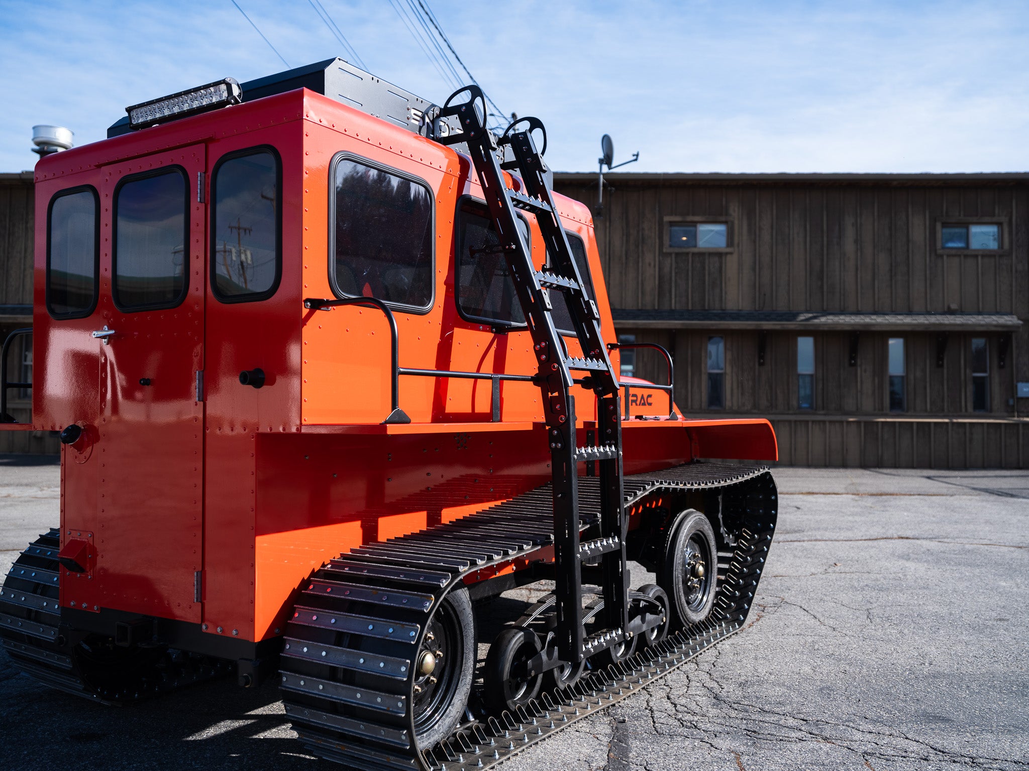 Back view of orange Sno Trac with ladder folded down