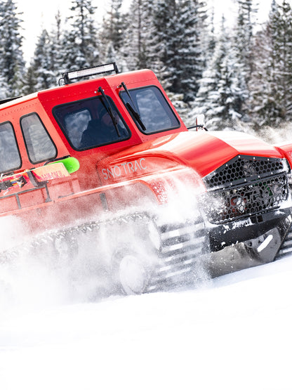 Red Sno Trac tracked vehicle driving through snowy backcountry
