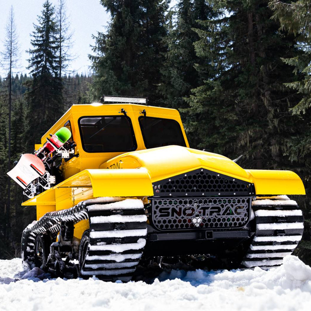 Yellow Sno Trac snow vehicle parked for backcountry recreation