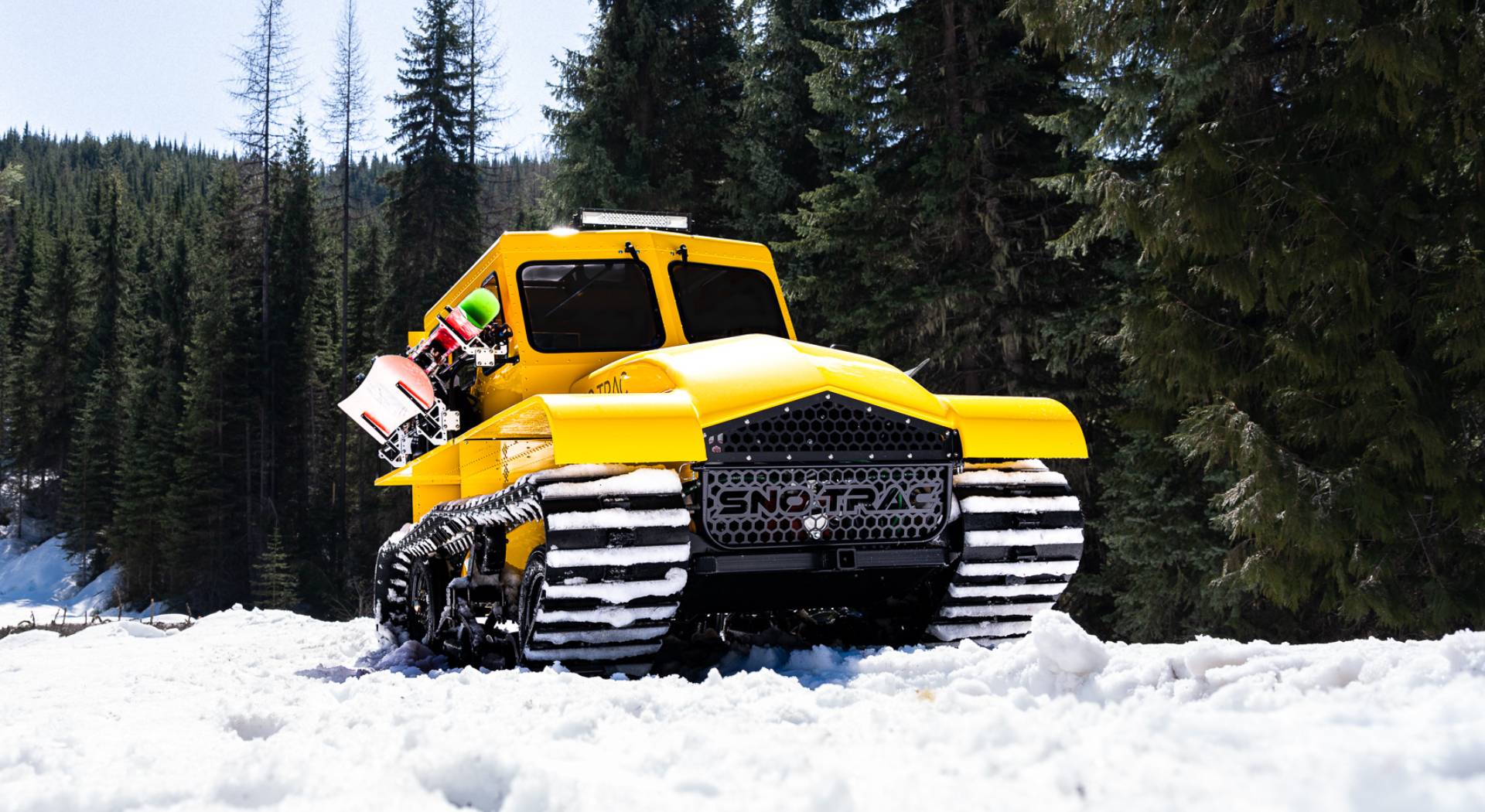 Yellow Sno Trac on a snowy hill for backcounty adventure